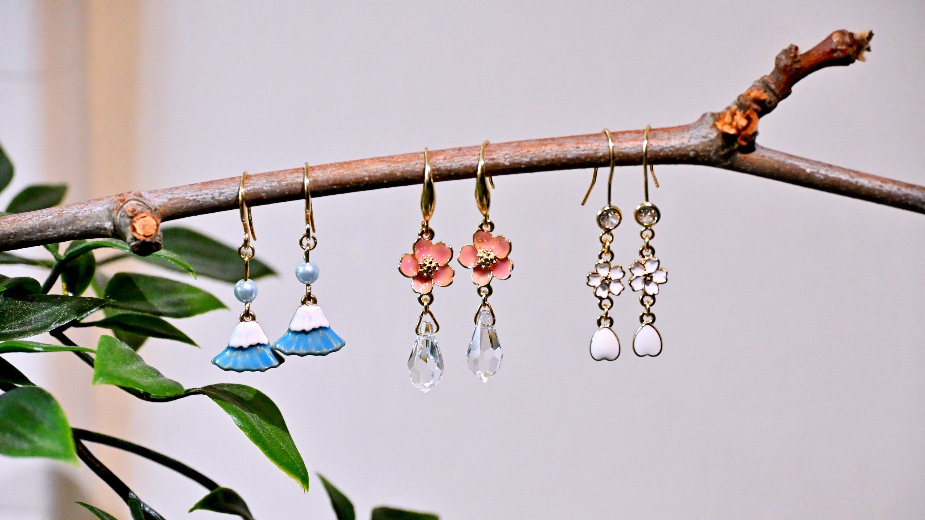 Japanese style earrings hanging from a branch with a natural background