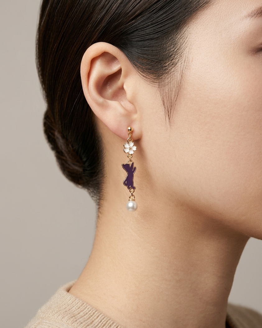 Model wearing a pair of earring with white sakura and purple cat charms with white pearl 
