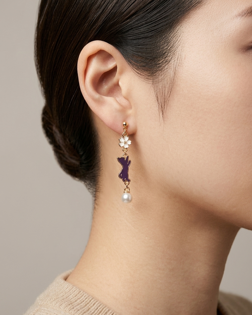 Model wearing a pair of earring with white sakura and purple cat charms with white pearl 